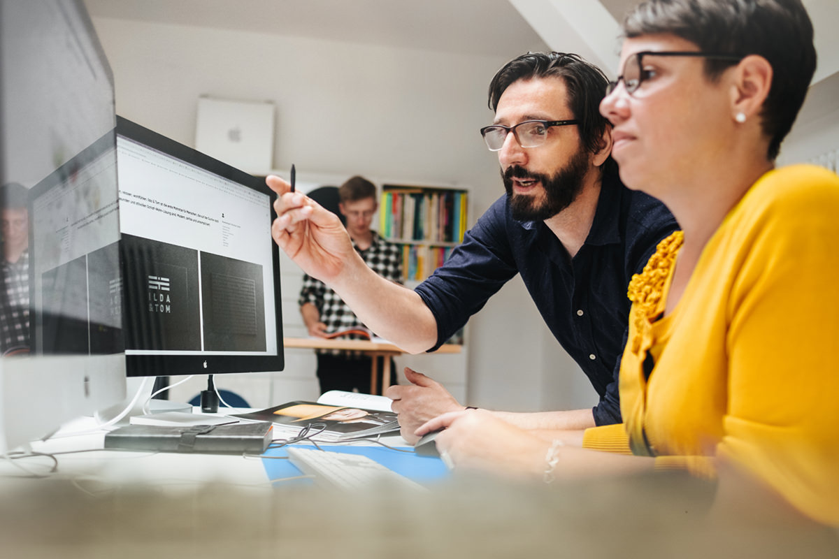 Webdesigner in Templin stehen vor einem Monitor und beraten